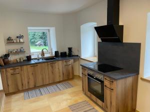 a kitchen with a sink and a stove top oven at Chalet am Bärenpfad in Neuschönau