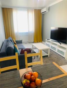 a living room with a bowl of fruit on a table at Толеби in Astana