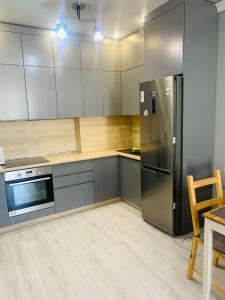 a kitchen with a stainless steel refrigerator and a table at Толеби in Astana