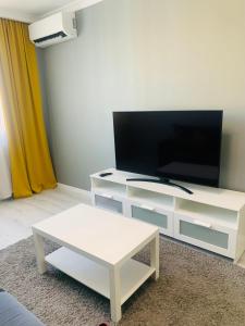 a living room with a white entertainment center with a flat screen tv at Толеби in Astana