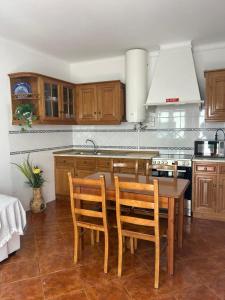 a kitchen with wooden cabinets and a table and chairs at Casa Reis in Odeceixe