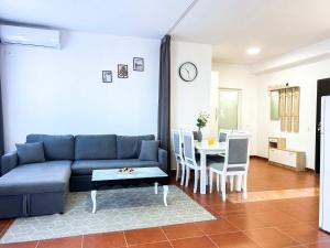 Una sala de estar con un sofá azul y una mesa. en SeaShell, en Golemasi