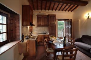 a kitchen with wooden cabinets and a table in a room at Azienda Agricola A Bonacchi in Montalcino