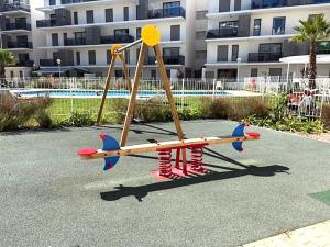 a playground with a play equipment in front of a building at Denia Apartment Rental - Vivir La Vida in Denia