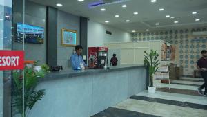 a man standing at a counter in a lobby at Hotel Holiday Fun Resort in Prāgpura +17 photos