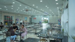 two people sitting at tables in a restaurant at Hotel Holiday Fun Resort in Prāgpura
