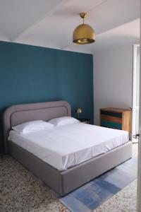 a bedroom with a large bed with a blue wall at Cocconato Bello e Buono in Cocconato