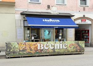 a store with a blue awning on the street at Beenie 5 in Linz