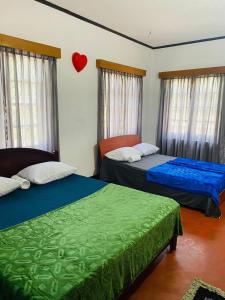 2 camas en una habitación con un corazón en la pared en Camellia Hill Nuwaraeliya, en Kandapola