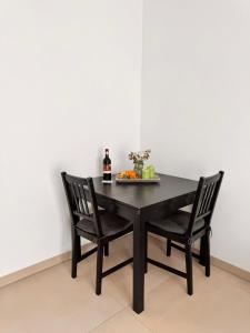 a black table with two chairs and a bottle of wine at Heni Apartments in Gau-Algesheim +8 photos
