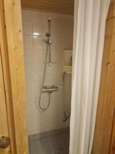 a shower in a bathroom with a shower curtain at Yllästölli 2B in Äkäslompolo