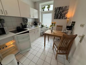 a kitchen with a table and a sink and a stove at Im Herzen City Kiel 1 Zi Whg pure Gemütlichkeit, eigener Parkplatz,10 m Fußweg zur Universität zu Kiel, 5 min zur Uniklinik, Ostsee, in Kiel