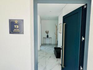 a hallway with a blue door and a tile floor at Vila Pombal Tomar - Luxury Apartment with private pool and Castle View in Tomar