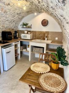 a kitchen with a table and a counter with a clock at La Cueva in La Garde-Adhémar