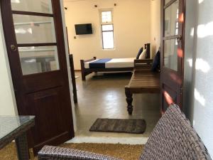 a room with a door and a bedroom with a bed at Ovenro Hotel Yala, Kataragama in Kataragama