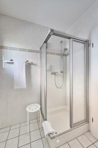 a bathroom with a shower with a stool in it at Pamir - 25 in Cuxhaven