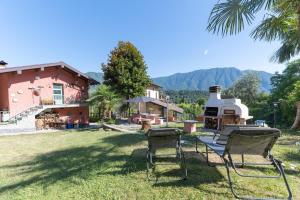 a group of chairs sitting in the grass in front of a house at Inas Lake Garden Elias Suite, Como Lake in Lenno