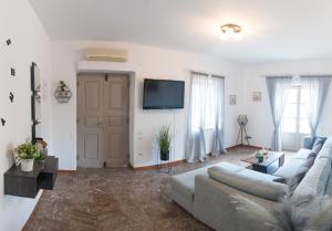 un soggiorno con divano e TV a schermo piatto di 270° a Hydra