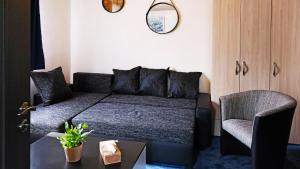 a living room with a couch and a chair at Chata se saunou přímo u lesa, nedaleko Hracholuské přehrady 