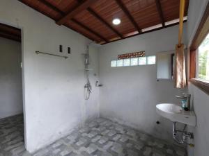 a white bathroom with a sink and a window at Casa Matā Phitā Cottage in Patjung +24 photos