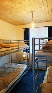 a room with three bunk beds and a ceiling at Chata se saunou přímo u lesa, nedaleko Hracholuské přehrady 