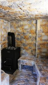 a stone wall with a stove in a room at Chata se saunou přímo u lesa, nedaleko Hracholuské přehrady 