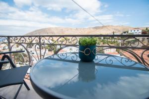 un tavolo di vetro con una pianta sopra un balcone di 270° a Hydra