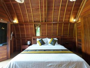 a bedroom with a bed in a wooden room at Casa Matā Phitā Cottage in Patjung