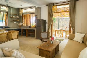 a kitchen and living room with a couch and a table at LAKE LOFT - La maison VEDA in Koggala