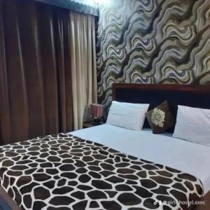 1 dormitorio con 1 cama con pared estampada en blanco y negro en Girls hostel Executive Karachi defence view, en Karachi