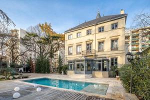 a large building with a swimming pool in front of it at Appartement 100m2 d'élégance au sein d'un Château caché à 10min de Lyon in Villeurbanne