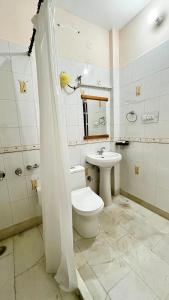 a white bathroom with a toilet and a sink at The Pahadi Ghar in Chail +23 photos