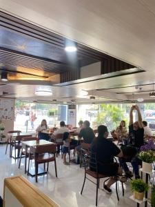 a group of people sitting at tables in a restaurant at Comfy Inn Manila-Kalaw in Manila +17 photos