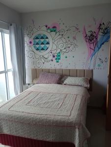a bedroom with a bed with a flower mural on the wall at Luxury Apartment COP 30 in Belém +14 photos