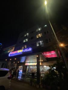a building with a neon sign on it at night at Comfy Inn Manila-Kalaw in Manila