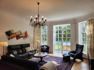 a living room with a couch and chairs and a chandelier at Wohnung im Zentum Neumünsters in Neumünster +28 photos
