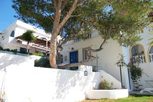 une maison blanche avec un arbre en face dans l'établissement Wavedance Accommodation, à Salamine