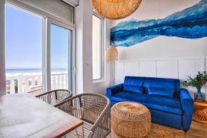 a living room with a blue couch and a table at Bleu Horizon in Villers-sur-Mer +3 photos