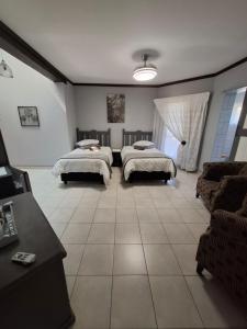 Jan KempdorpにあるVilla Caramia Guest Lodgeのベッド2台とソファのあるリビングルーム +53枚の写真
