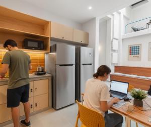 モンテビデオにあるCasa Gabotoのキッチンでノートパソコンを持つ男性と女性