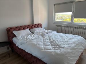 a large bed in a bedroom with a large window at Casa8tima in Bistriţa