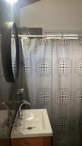 un bagno con lavandino e tenda da doccia di Cabaña Carmanqui ad Alpa Corral