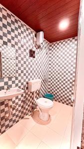 a bathroom with a toilet and a sink at Sunshine Guest House in Calangute