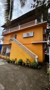 a yellow building with plants in front of it at Sunshine Guest House in Calangute +2 photos
