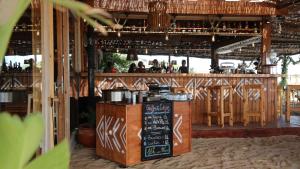 a restaurant with a bar with a counter with a chalkboard at Océan Vagabond Lassarga in Dakhla