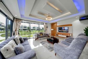 Una sala de estar con sofás y un televisor. en Luxury 2-Bedroom Apartment with Pool & Garden View, Lekki Lakowe Lakes Estate, en Lakowe