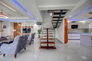 escalera en una sala de estar con sillas y mesa en Luxury 2-Bedroom Apartment with Pool & Garden View, Lekki Lakowe Lakes Estate, en Lakowe