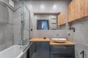 Un baño con lavabo y ducha de cristal. en MDM Apartments, en Gdansk