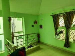 a green room with a balcony and two windows at Holiday villa in Kolkata +2 photos