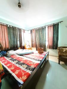 コルカタにあるHoliday villaの窓のある部屋にある大きなベッドのある寝室